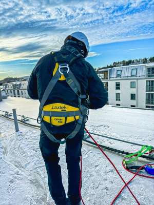 fallskyddssele expert pro 200 på snöigt tak bakifrån med blå himmel