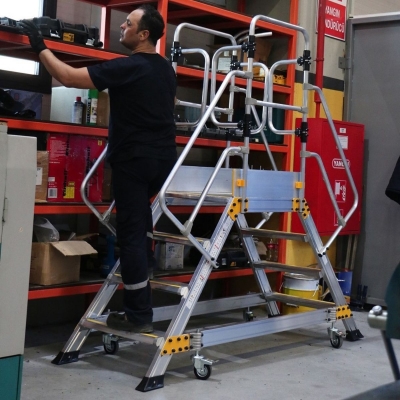 Miljöbild där en man med svarta arbetskläder står på en dubbelsidad arbetsplattform