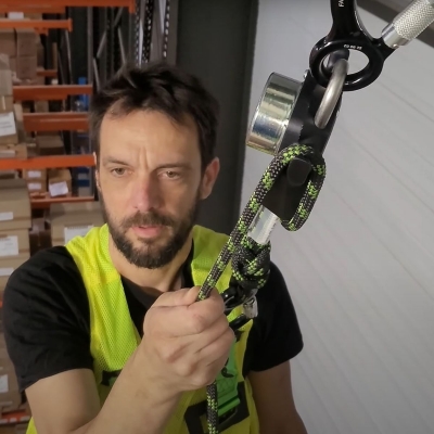 Grönt och svart evakueringspaket för snabb nedfirning miljöbild in action med man som firar sig ner