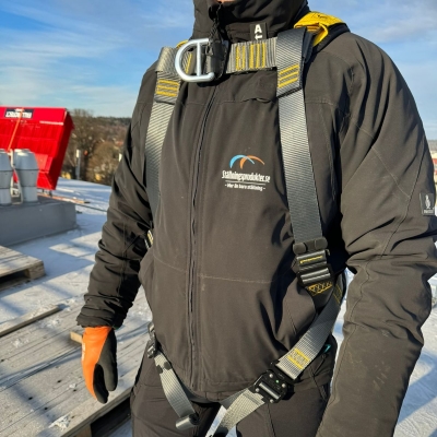 svart och gul fallskyddssele på man på frostigt tak