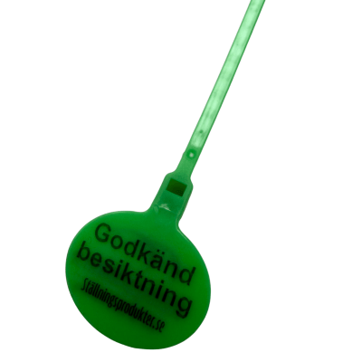 Närbild på grön besiktningsskylt som tydligt visar märkningen och den slitstarka plastkonstruktionen.