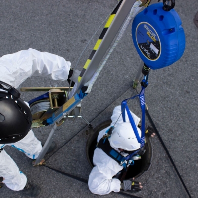 Blå nedfirningssling för tripod med man som firas ner i brun med tripod