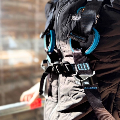 blå och svart fallskyddssele wind 1 pro på modell i ställning