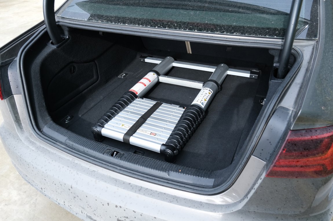 En grå Teleskåpstege i bagaget av en bil