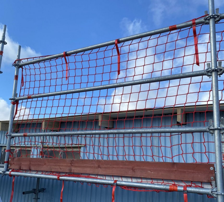 rött skyddsräckesnät för byggställning monterad på skyddsräcke för fallskydd för tak